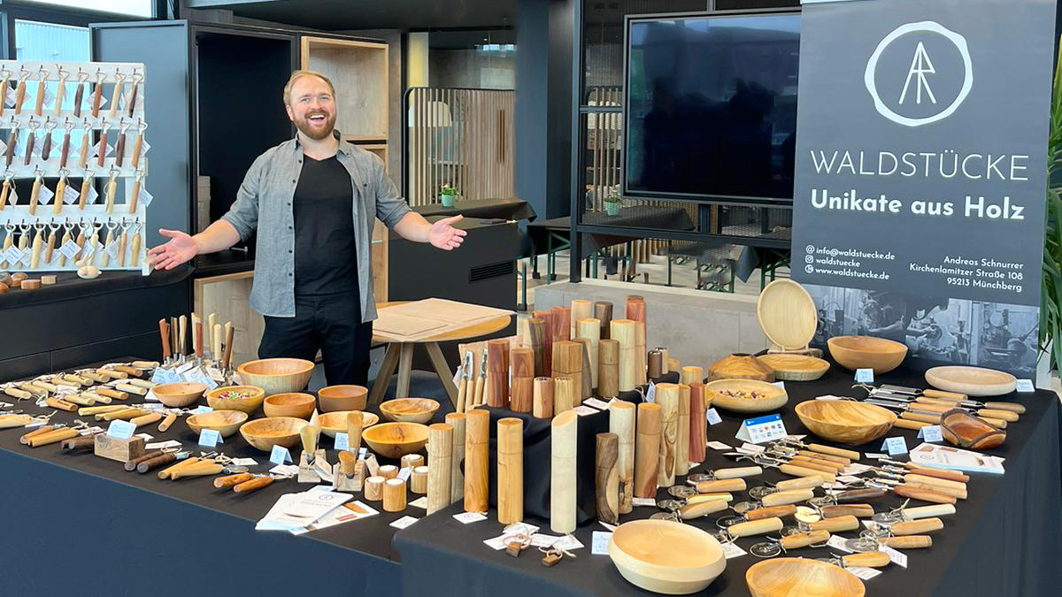 Andreas Schnurrer präsentiert seine Unikate auf einem Marktstand in einem Autohaus.